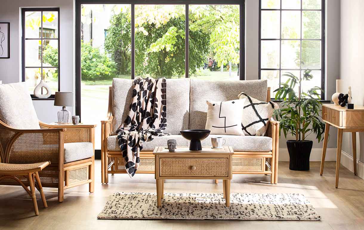 cane conservatory furniture with scatter cushions, coffee table and throw