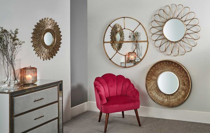 Gold wall mirrors and fuchsia velvet accent chair