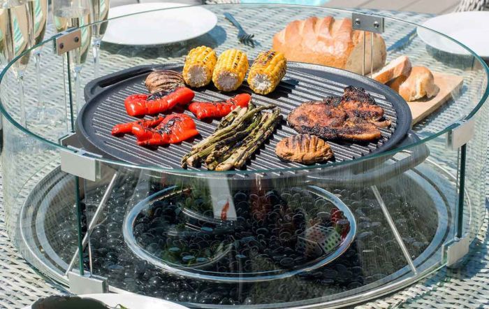 This garden table has a firepit with a griddle on top