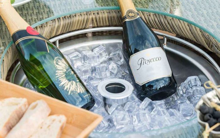 A close up of a built in ice bucket with bottles of prosecco in